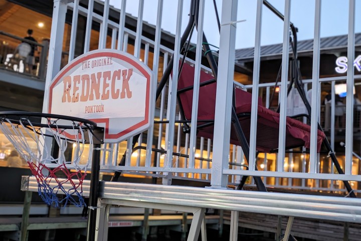 Redneck pontoon sign with basketball hoop on a dock.